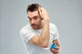 Happy young man styling his hair with wax or gel Royalty Free Stock Photo