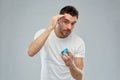 Happy young man styling his hair with wax or gel Royalty Free Stock Photo