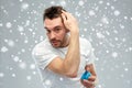 Happy young man styling his hair with wax or gel Royalty Free Stock Photo