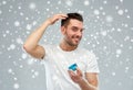 Happy young man styling his hair with wax or gel Royalty Free Stock Photo