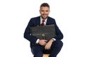 Happy young man in suit holding bag and smiling Royalty Free Stock Photo