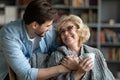 Happy young man taking care of elderly happy mother. Royalty Free Stock Photo