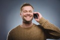 Happy young man talking on cell phone isolated on gray background Royalty Free Stock Photo