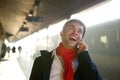 Happy young man talking on mobile phone at train station Royalty Free Stock Photo