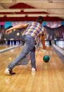 Happy young man throwing ball in bowling club Royalty Free Stock Photo