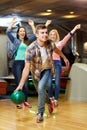 Happy young man throwing ball in bowling club Royalty Free Stock Photo