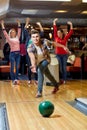 Happy young man throwing ball in bowling club Royalty Free Stock Photo