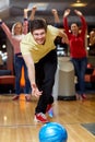 Happy young man throwing ball in bowling club Royalty Free Stock Photo