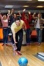 Happy young man throwing ball in bowling club Royalty Free Stock Photo