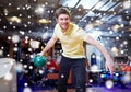 Happy young man throwing ball in bowling club Royalty Free Stock Photo