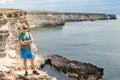 Happy young man on top of cliff enjoying view of sea. Mountains and sea Royalty Free Stock Photo