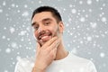 Happy young man touching his face or beard Royalty Free Stock Photo