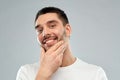 Happy young man touching his face or beard Royalty Free Stock Photo