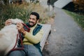 Happy young man training and cuddling with his dog outdoors in city park, during cold autumn day. Royalty Free Stock Photo