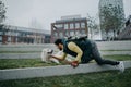 Happy young man training and cuddling with his dog outdoors in city park, during cold autumn day. Royalty Free Stock Photo