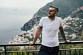 Happy young man traveler smiling at italian coast view.Man traveling to European south coast.Enoying sunny weather medditerranean Royalty Free Stock Photo