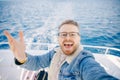 Happy young man on trip on white yacht sea making selfie photo on camera, concept travel life hipster Royalty Free Stock Photo