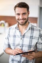 Happy young man using digital tablet in kitchen Royalty Free Stock Photo