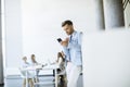 Happy young man using his mobile phone and smiling while his colleagues working in the background Royalty Free Stock Photo