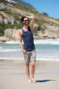 Happy young man on vacation walking barefoot on beach Royalty Free Stock Photo