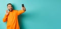 Happy young man video calling, talking online with mobile phone, saying hello to smartphone camera and waving hand Royalty Free Stock Photo