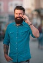 Happy young man walking on the street while talking by mobile phone. Royalty Free Stock Photo