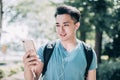 Happy young man  walking on street and using mobile phone Royalty Free Stock Photo