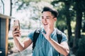 Happy young man  walking on street and using mobile phone for video conference Royalty Free Stock Photo