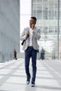 Happy young man walking and talking on mobile phone Royalty Free Stock Photo