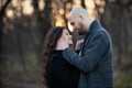 Happy young man and woman caress each other while standing in the park