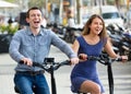 Happy young man and woman with electrkc bikes