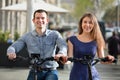 Happy young man and woman with electrkc bikes