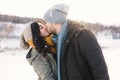 A happy young man and woman kissing in winter enjoying life and