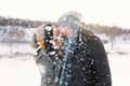 A happy young man and woman kissing in winter enjoying life and