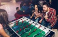 Happy young man and woman playing together in room. Intense game. Winning and loosing. Opponents at table soccer. Royalty Free Stock Photo