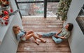 Happy young man and woman sitting on the kitchen floor holding wine glasses with the toast. New year& x27;s eve. Top view