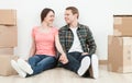 Happy young man and woman sitting near cardboard boxes Royalty Free Stock Photo