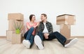 Happy young man and woman sitting near cardboard boxes Royalty Free Stock Photo