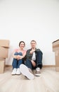 Happy young man and woman sitting near cardboard boxes Royalty Free Stock Photo