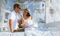 Happy young man and woman sitting under a beautiful white baldachin