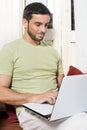 Happy Young Man Working on Laptop at Home Royalty Free Stock Photo