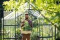 Happy young man working outdoors in backyard, gardening and greenhouse concept. Royalty Free Stock Photo