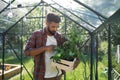 Happy young man working outdoors in backyard, gardening and greenhouse concept. Royalty Free Stock Photo