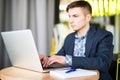 Happy young man works on his laptop to get all his business done early in the morning with his cup of coffee Royalty Free Stock Photo