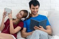 Happy young couple relaxing together at home. with the wife lying back against her husband as she listen to music on a Royalty Free Stock Photo