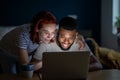 Happy young married multiracial couple using laptop together at home, planning summer vacation Royalty Free Stock Photo