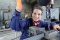 happy young mechanic apprentice working on milling machine