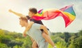 Happy young men, gay family with flying LGBT rainbow flag having fun outdoors. Joyful gay couple together in a park Royalty Free Stock Photo