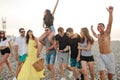 Group of Friends Walking at Beach, having fun, womans piggyback on mans, funny vacation Royalty Free Stock Photo