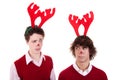 Happy young men wearing reindeer horns, admired